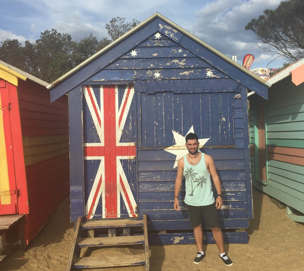 Dani en Australia chico joven en una casita con la bandera australiana en la playa de Melbourne